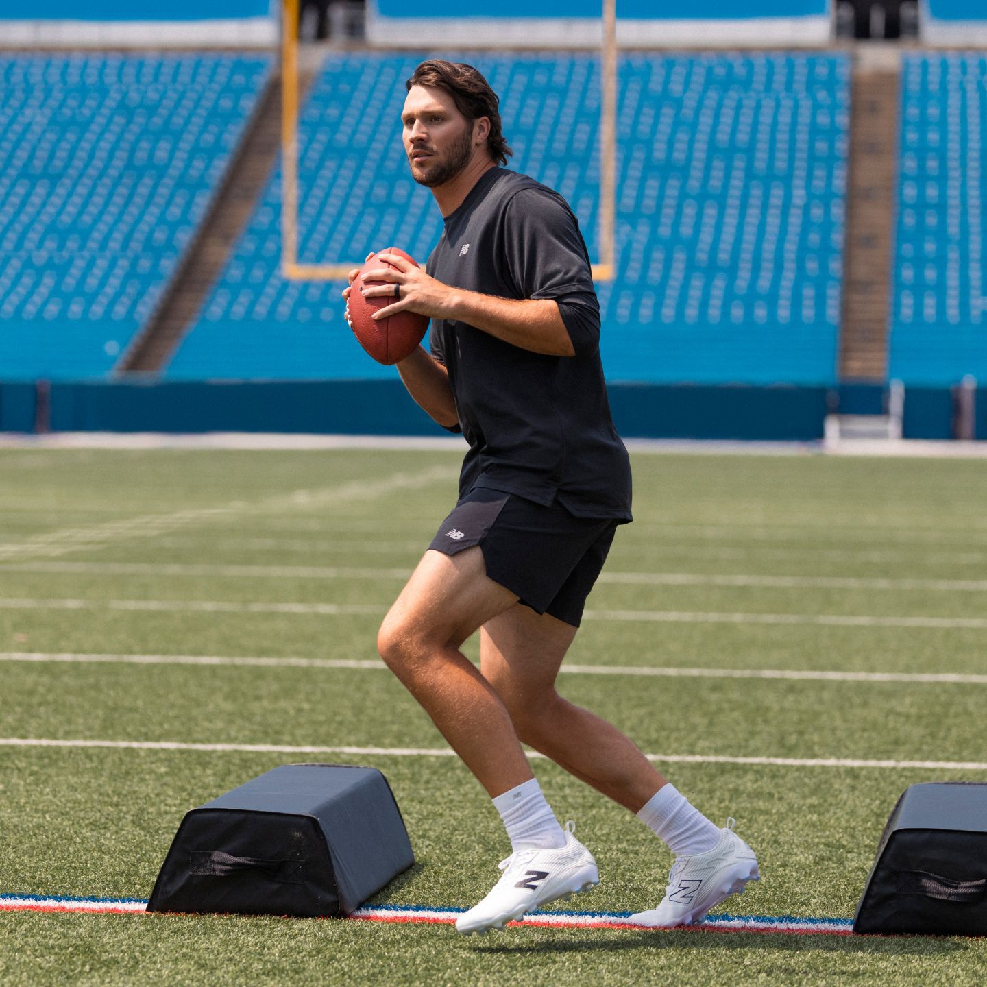 Josh Allen holding a football on a field.