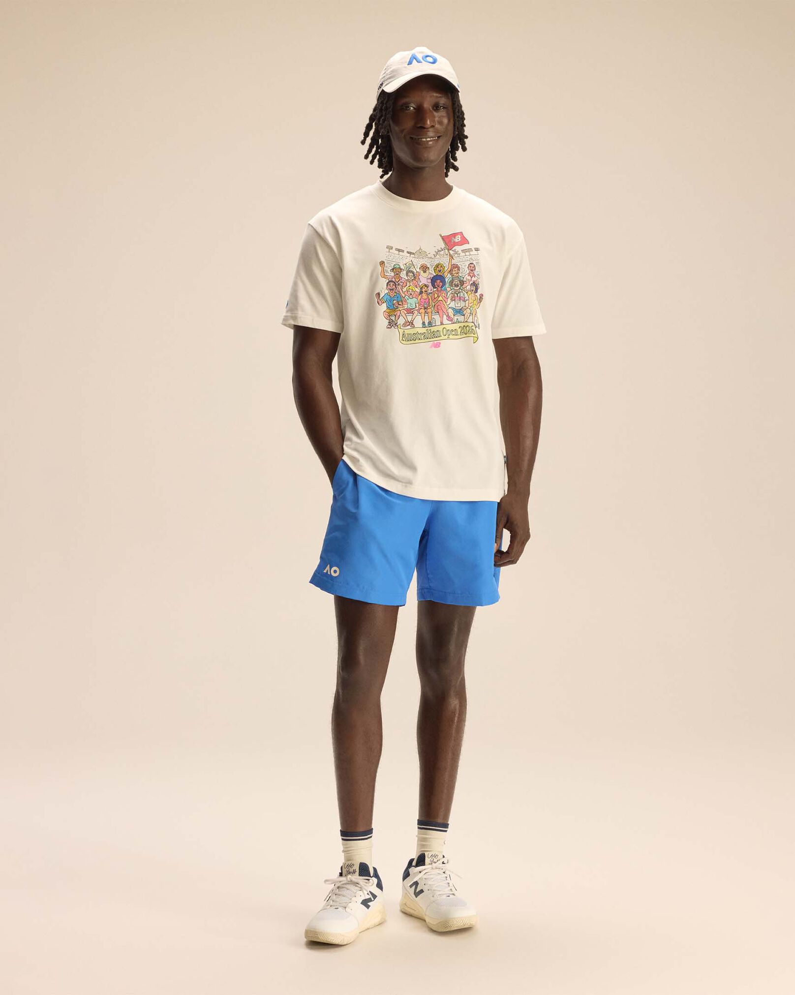 A person standing against a tan studio backdrop.