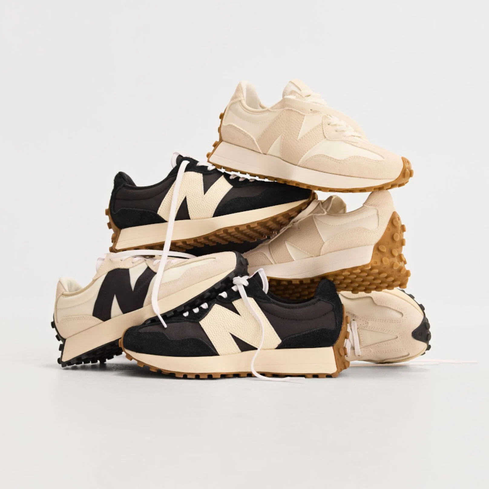 Pile of multiple New Balance sneakers on white background.