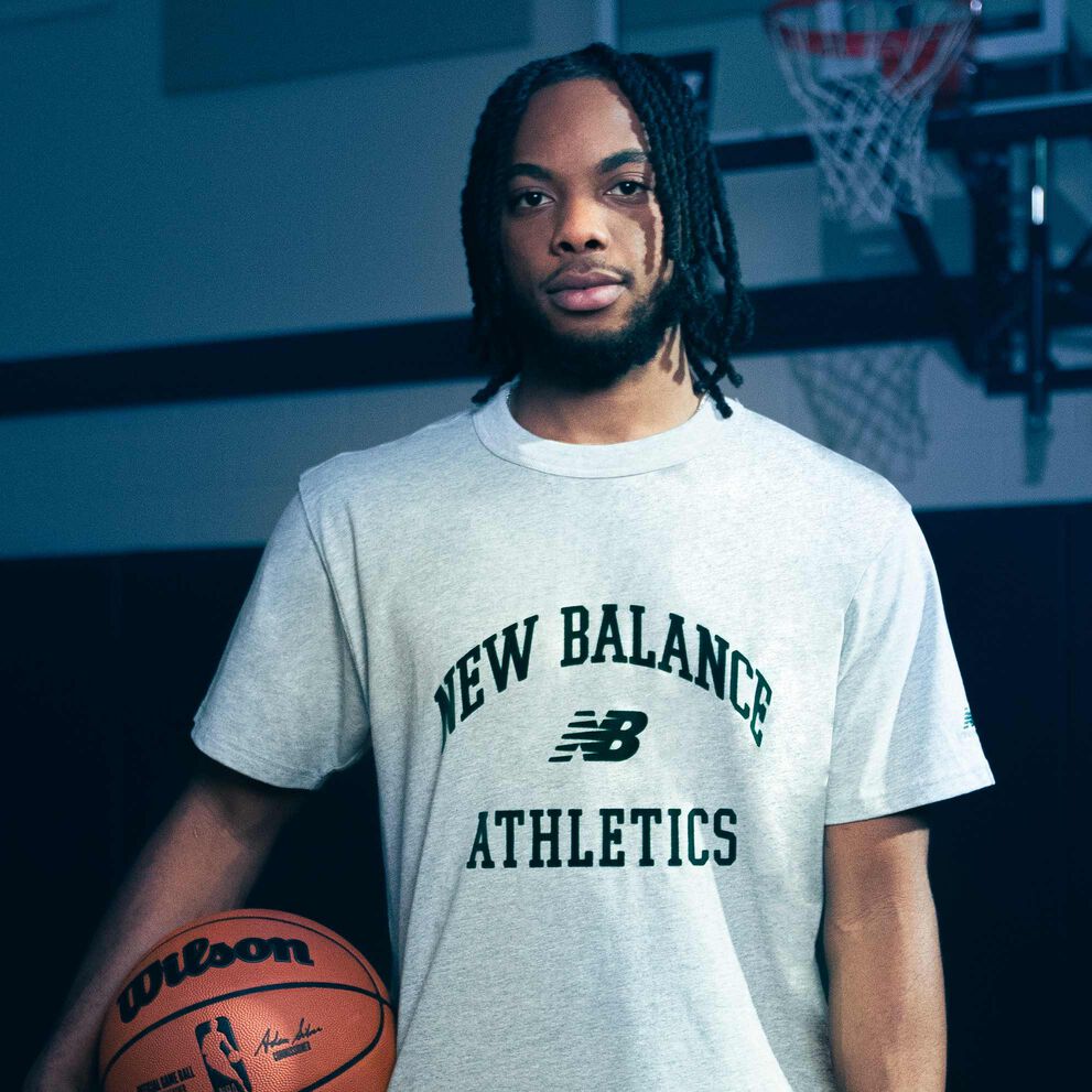 Darius Garland de pie en un gimnasio sosteniendo una pelota de baloncesto.