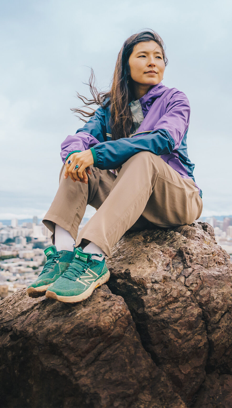 Woman sitting on a rock, wearing Parks Project & NB Apparel and Fresh Foam X Hierro v7 