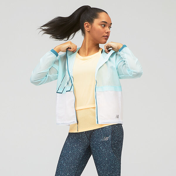 Young woman wearing a light blue jacket with a yellow tank. 