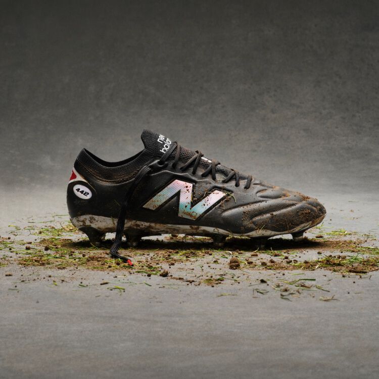 Black and white cleats with dirt on them