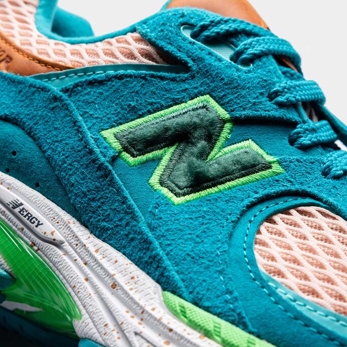 Detail shot of a NB x Salehe Bembury 2002R sneaker with turquoise hairy suede and orange leather and lime green accents
