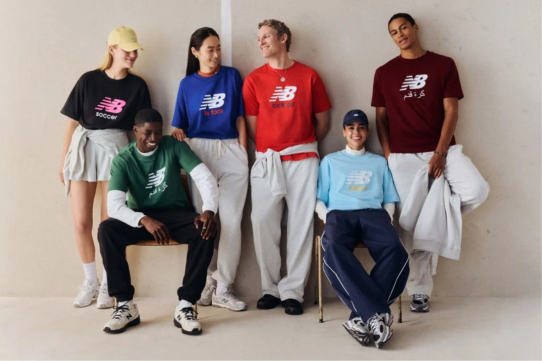 A group of people wearing different color soccer graphic t-shirts.