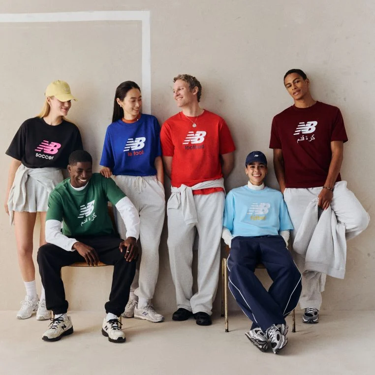 A group of people wearing different color soccer graphic t-shirts.