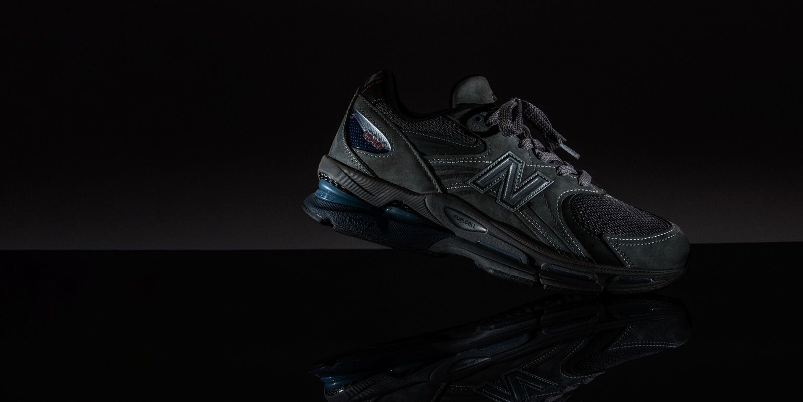 A dark shoe in a black studio environment.  