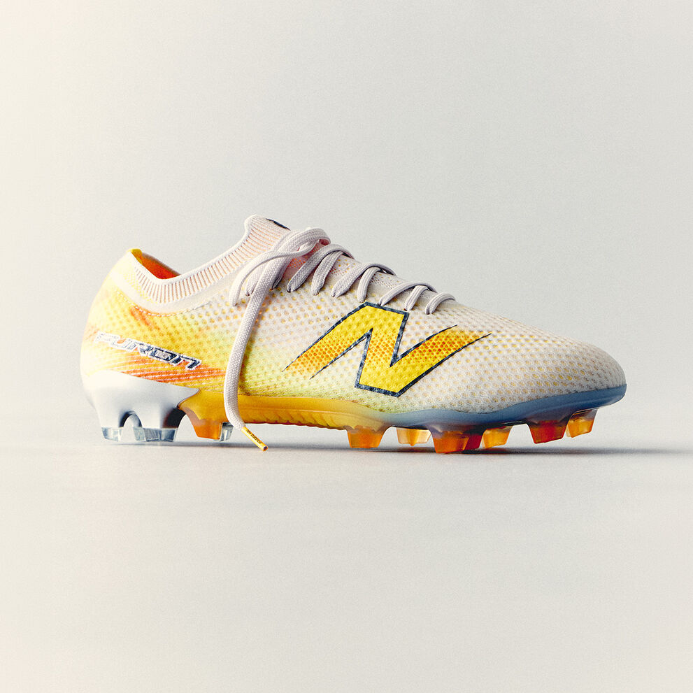 White and yellow New Balance soccer cleat with a lightweight mesh upper and molded studs displayed against a clean white background.