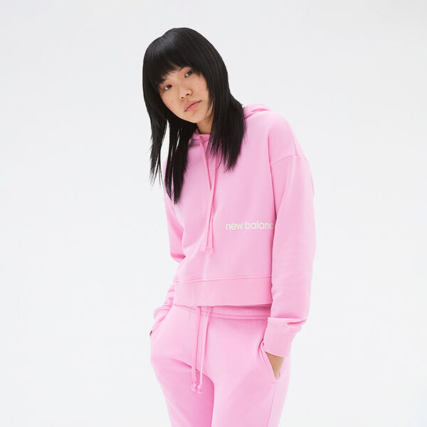 Woman wearing a matching light-pink NB hoodie and sweatpants