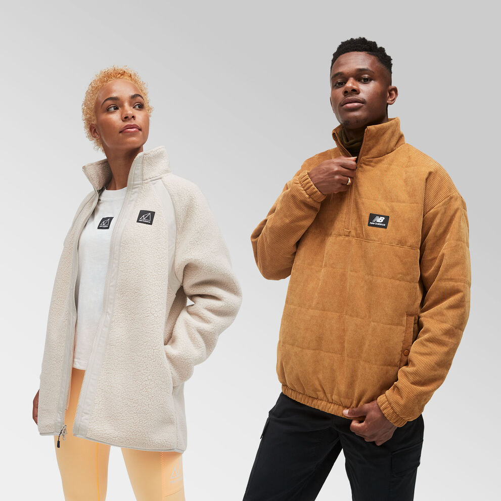 A woman wearing a cream-colored NB All Terrain jacket posing with a man wearing a caramel-colored corduroy NB Athletics Winterized Anorak  