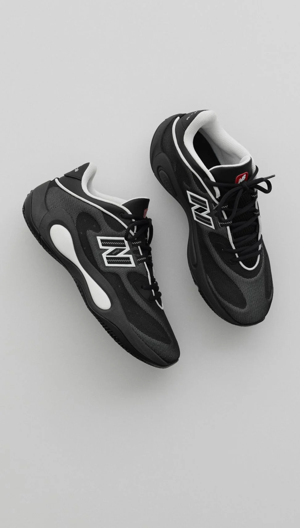 A pair of black and white P400 Low shoes on a grey background.