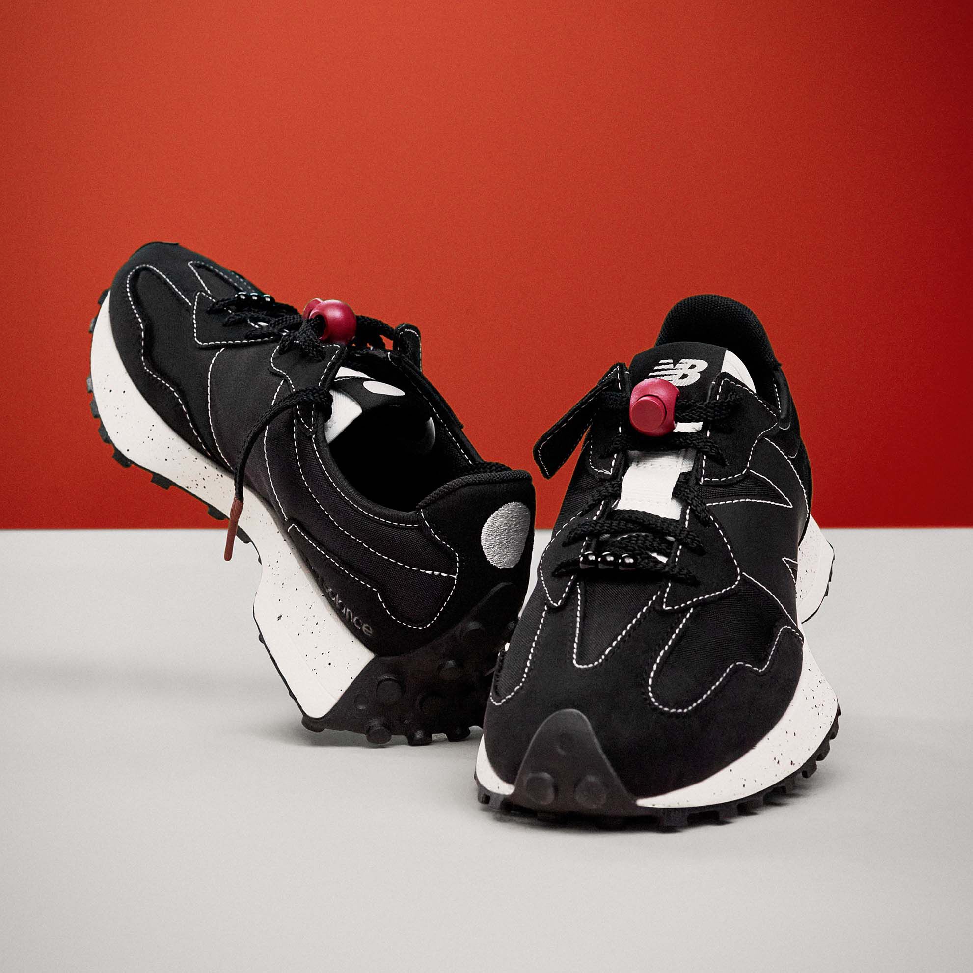 Pair of black and white 327 shoes posed in grey studio background with red backdrop