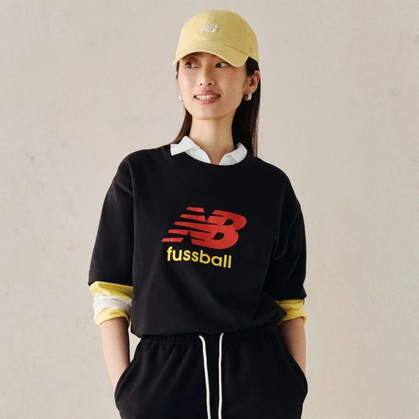 A person wearing a soccer graphic tee.