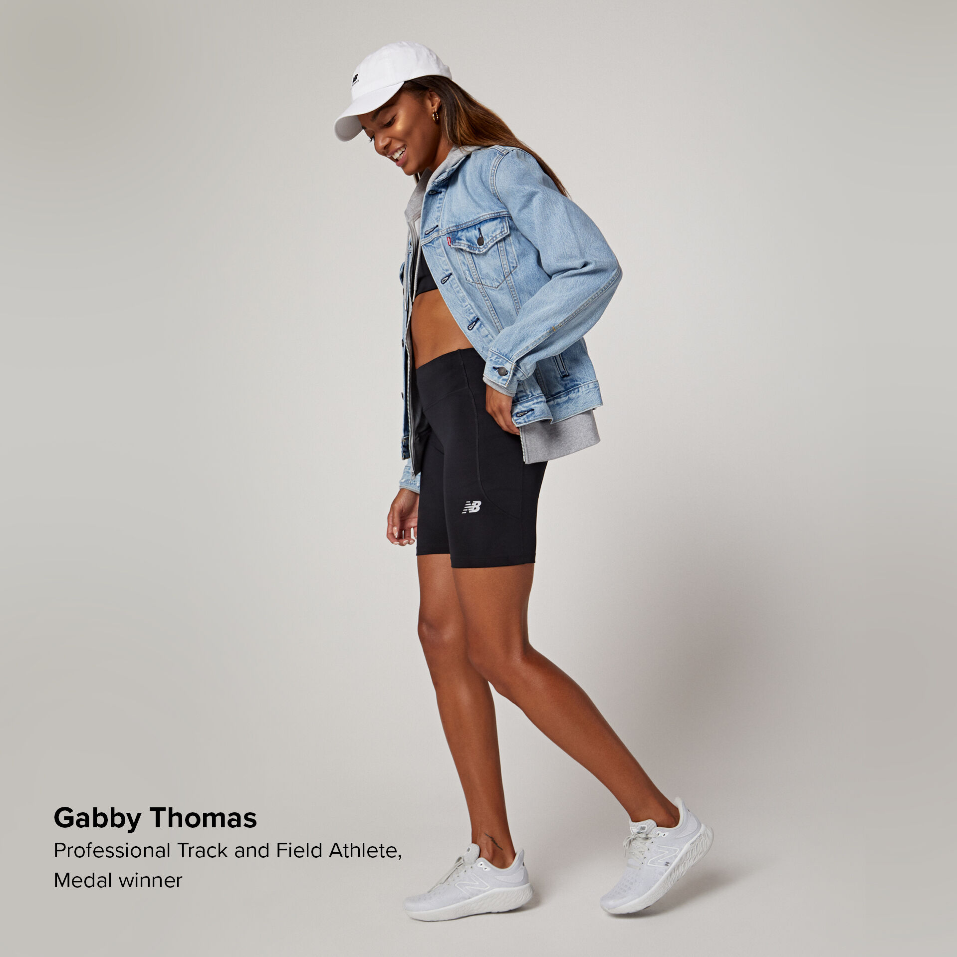 Young athlete posing in a jean jacket and black shorts.