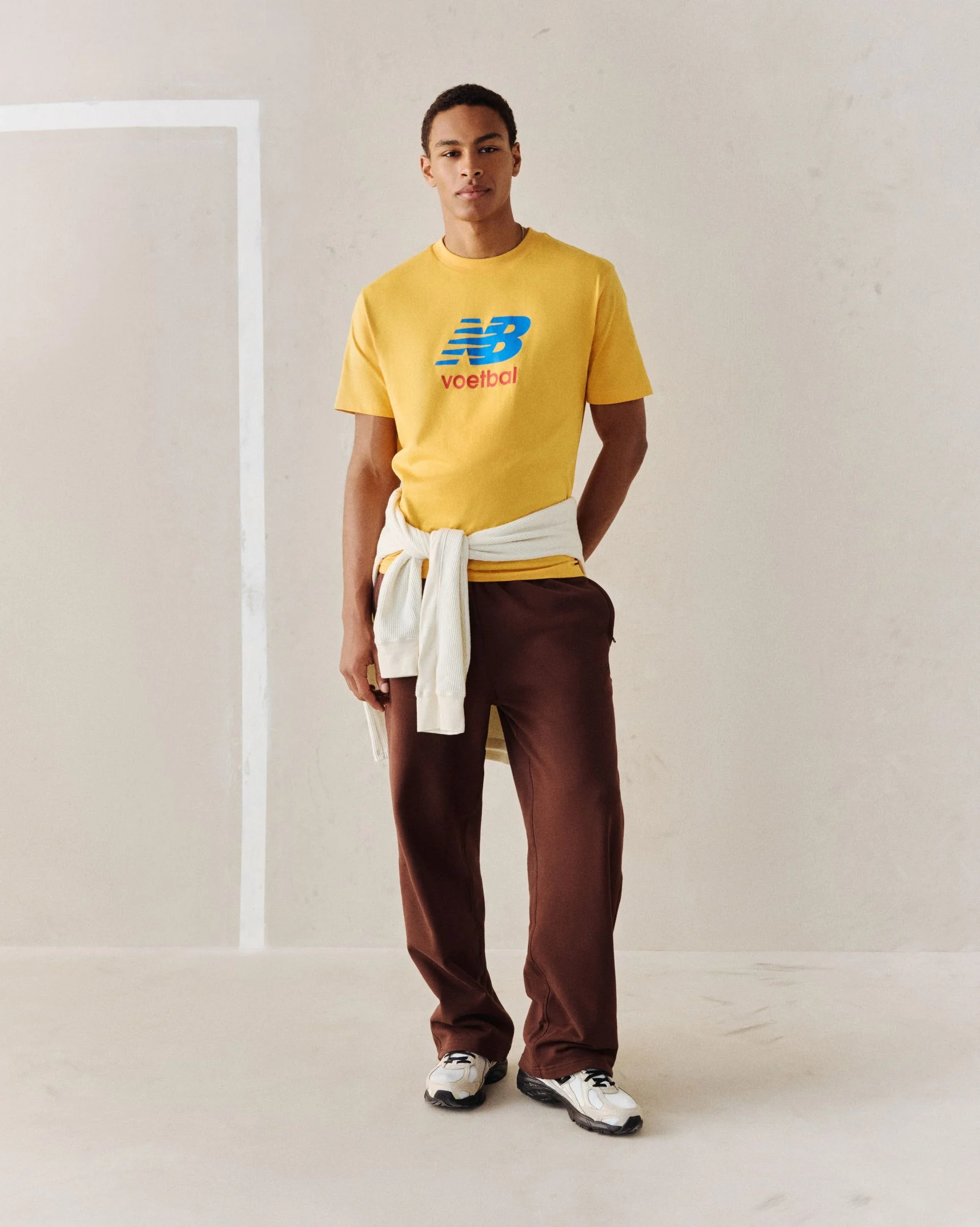 A person wearing a yellow soccer graphic tee.