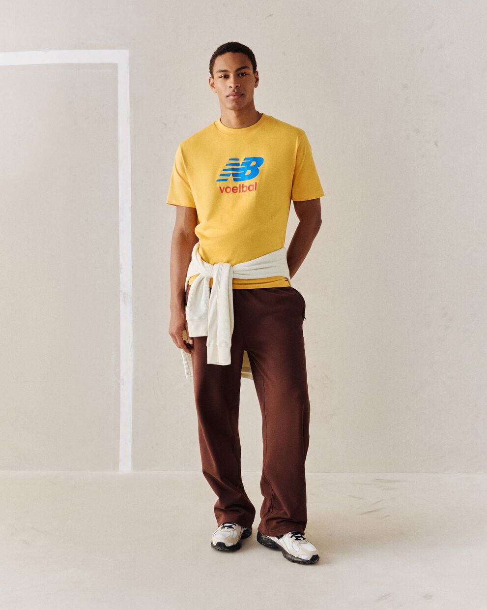 A person wearing a yellow soccer graphic tee.