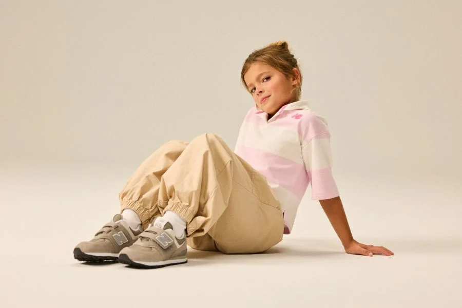Girl wearing a pair of grey 574 shoes.
