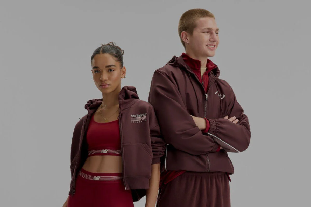  A man and woman wearing burgundy and red New Balance gear on a white background..