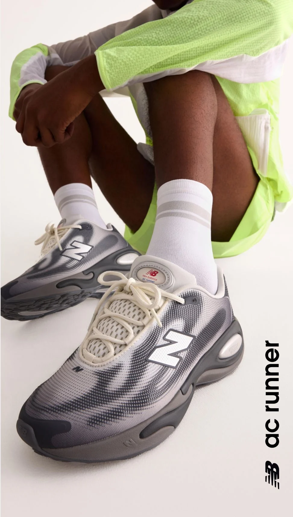 Knee down angle of a person wearing grey AC Runner shoes. 