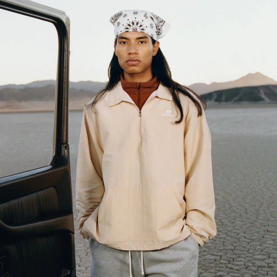 A man standing next to an open car door in a desert environment.