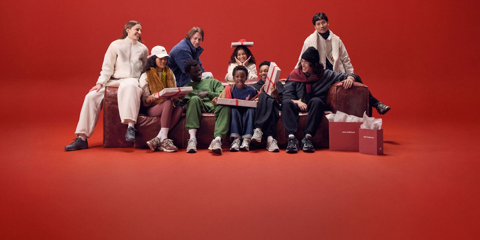 Young family sitting on a red couch with gifts.