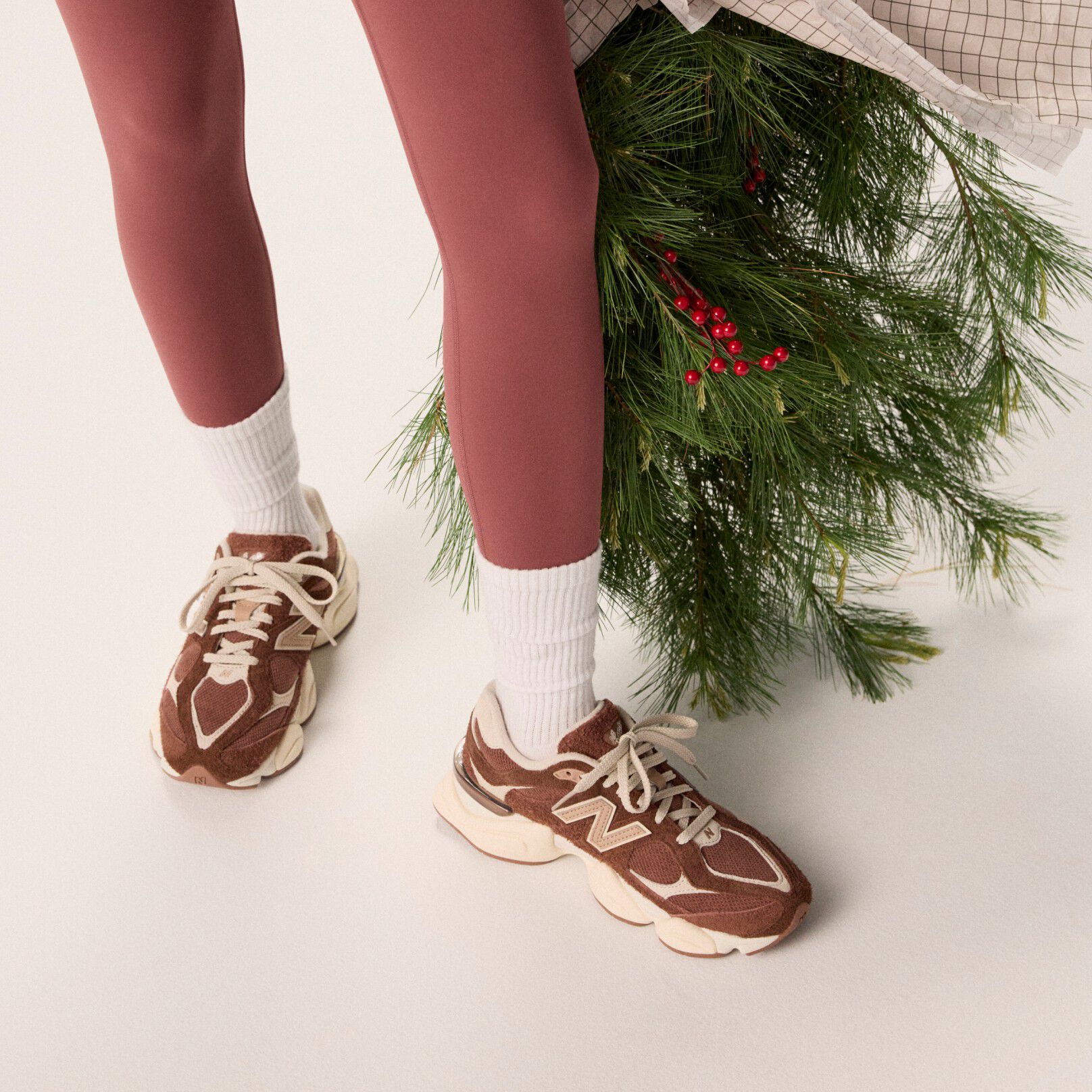 Young woman in maroon tights holding a bag of garland.