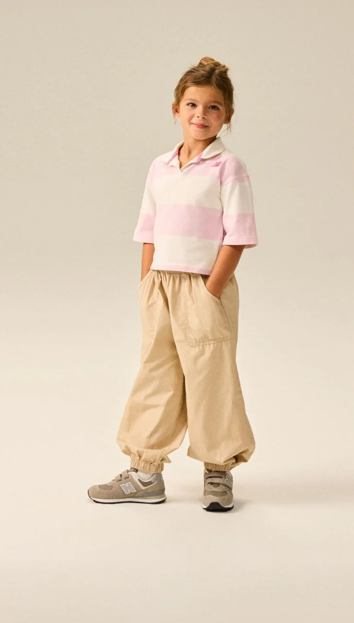 Girl wearing a pair of grey 574 shoes.