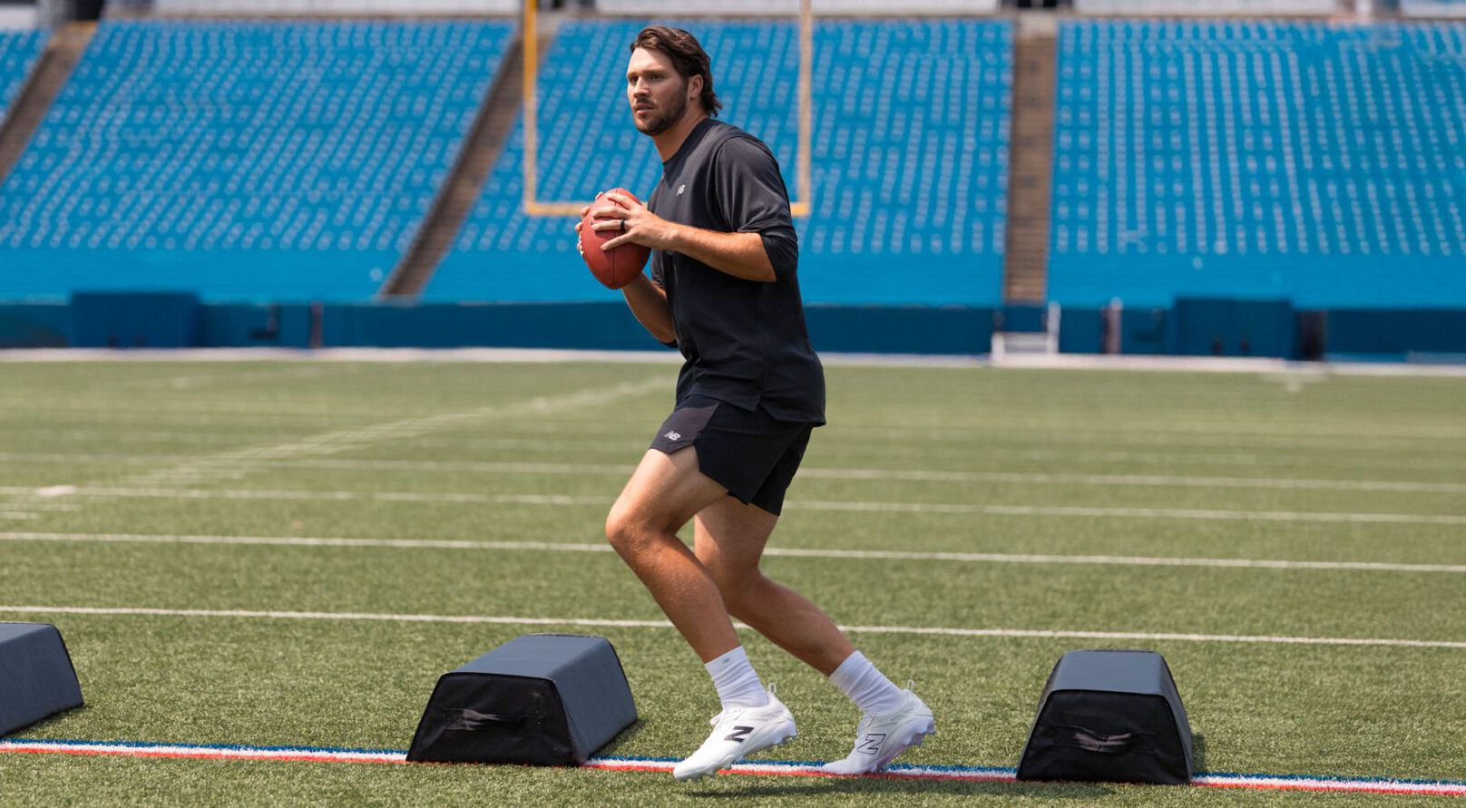 Josh Allen holding a football on a field.