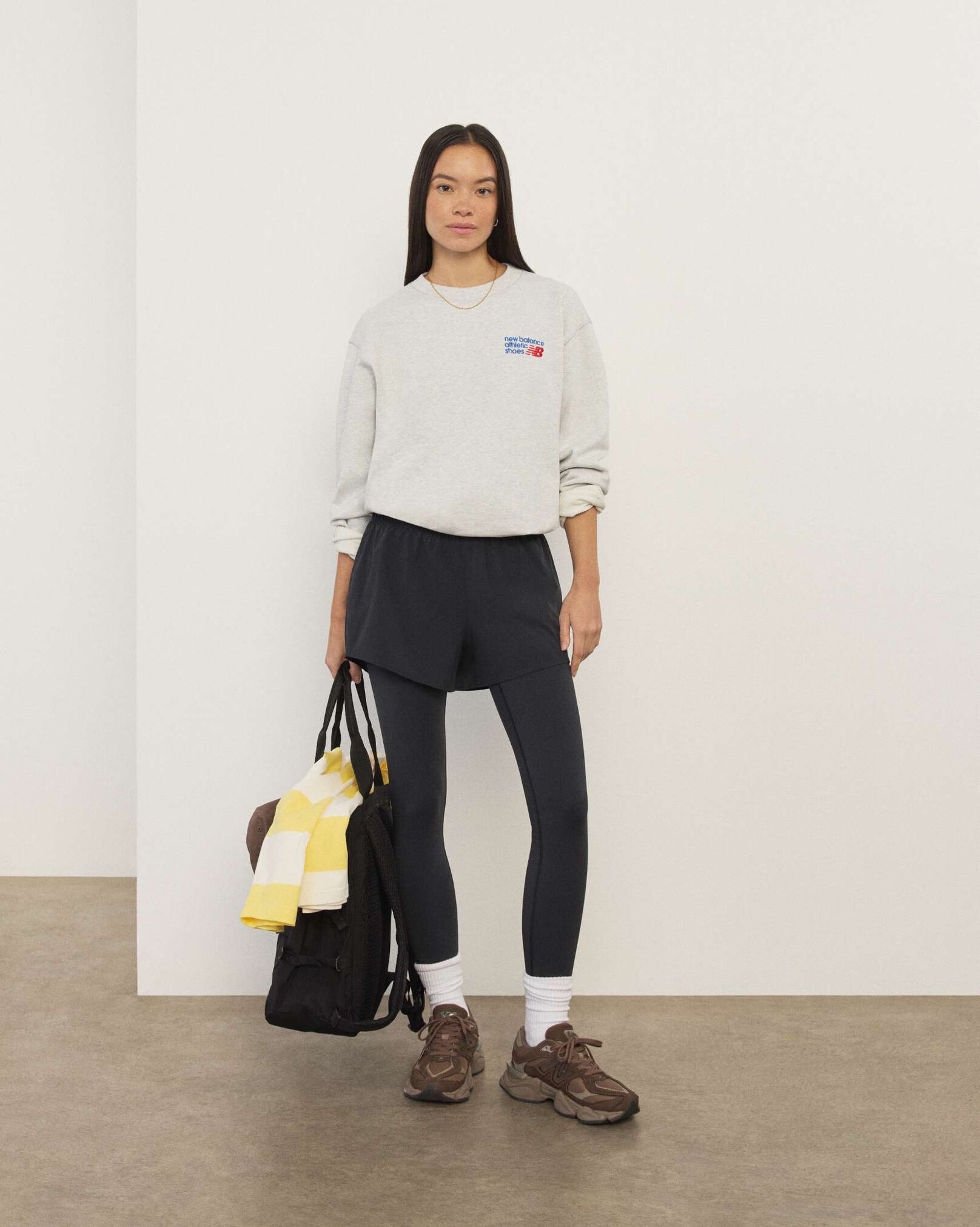 A woman standing in front a white wall.