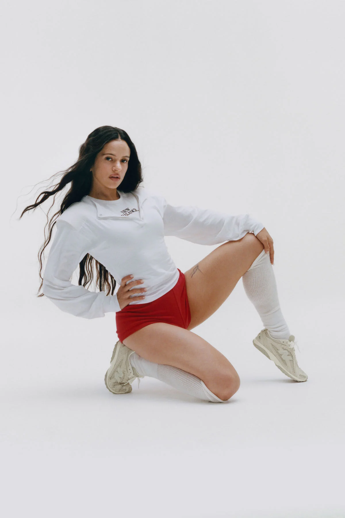 Rosal&iacute;a sitting on a white studio backdrop.