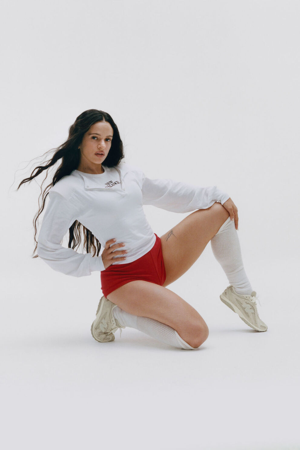 Rosal&iacute;a sitting on a white studio backdrop.
