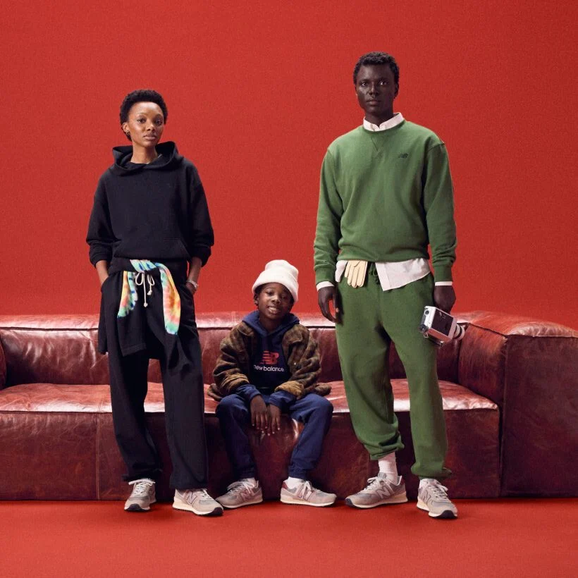 Family sitting around a red couch on a red background.