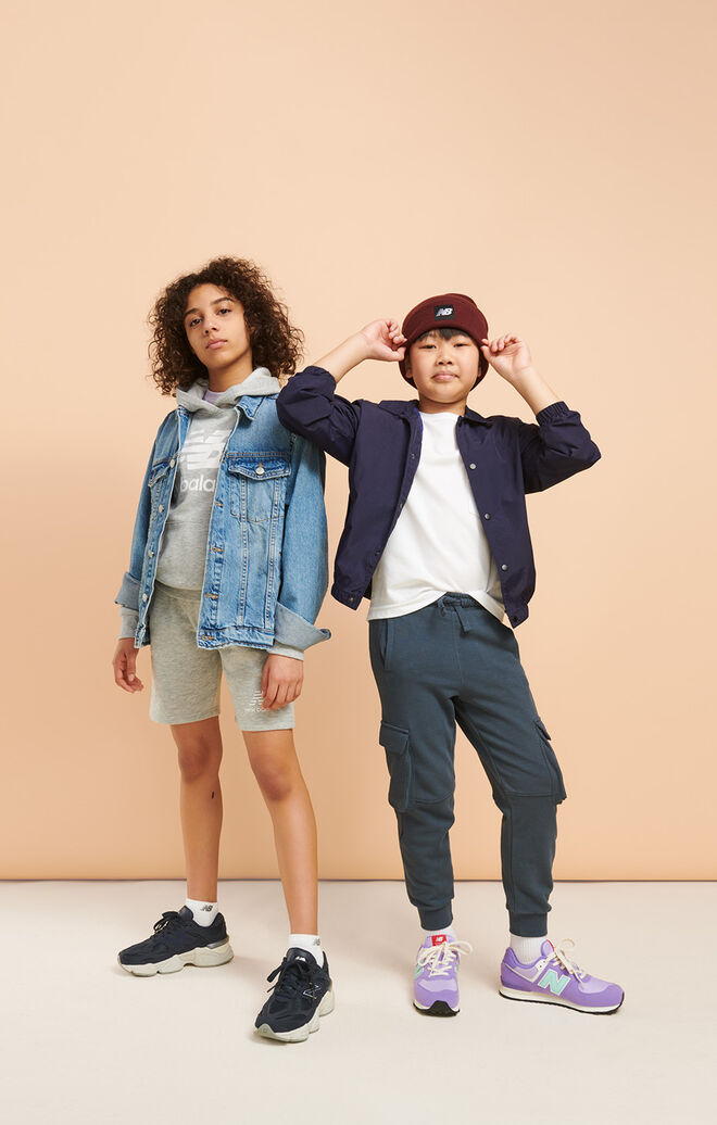 Two young kids posing together in head-to-toe NB gear