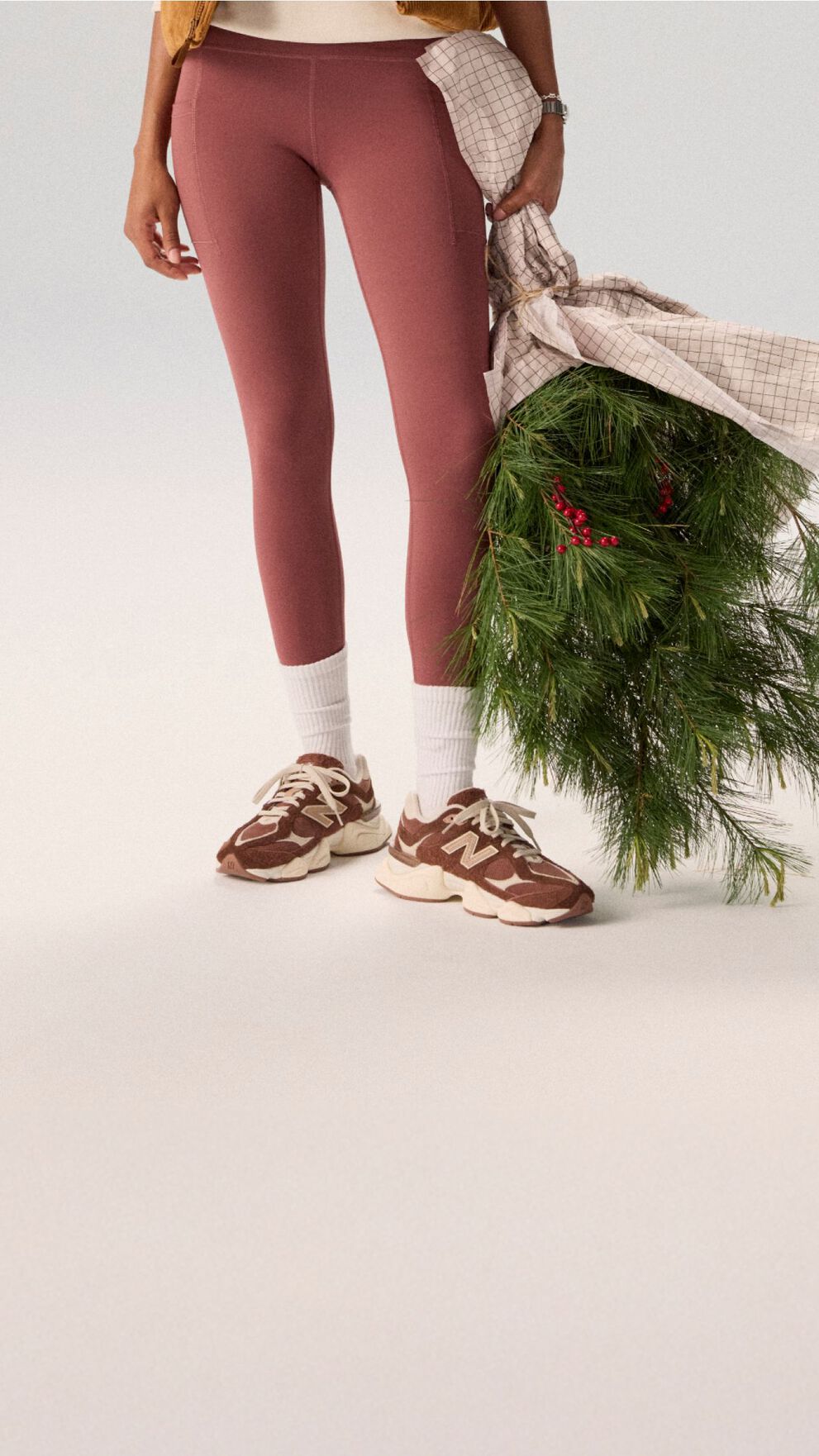 Young woman in maroon tights holding a bag of garland.