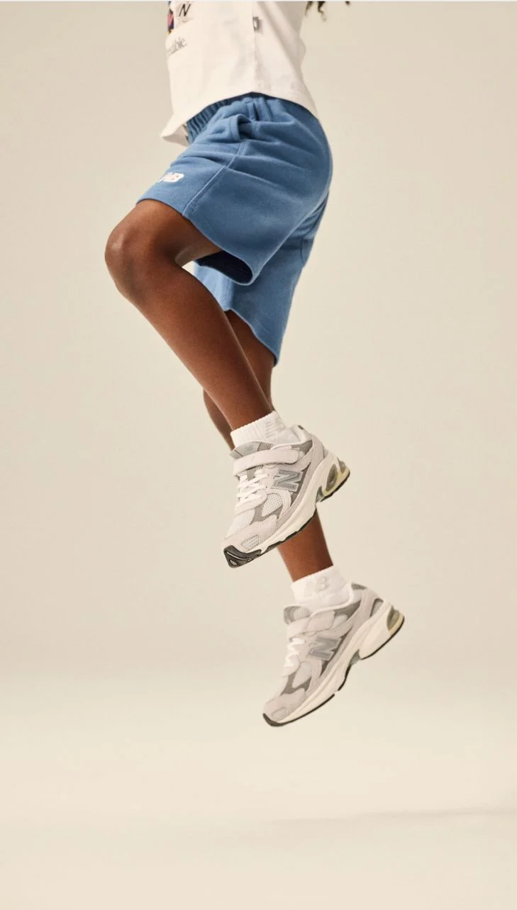 Knee down image of kid wearing a pair of 2010 shoes. 