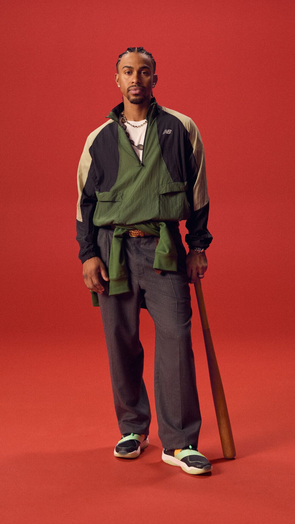 Baseball athlete holding a bat on a red background.