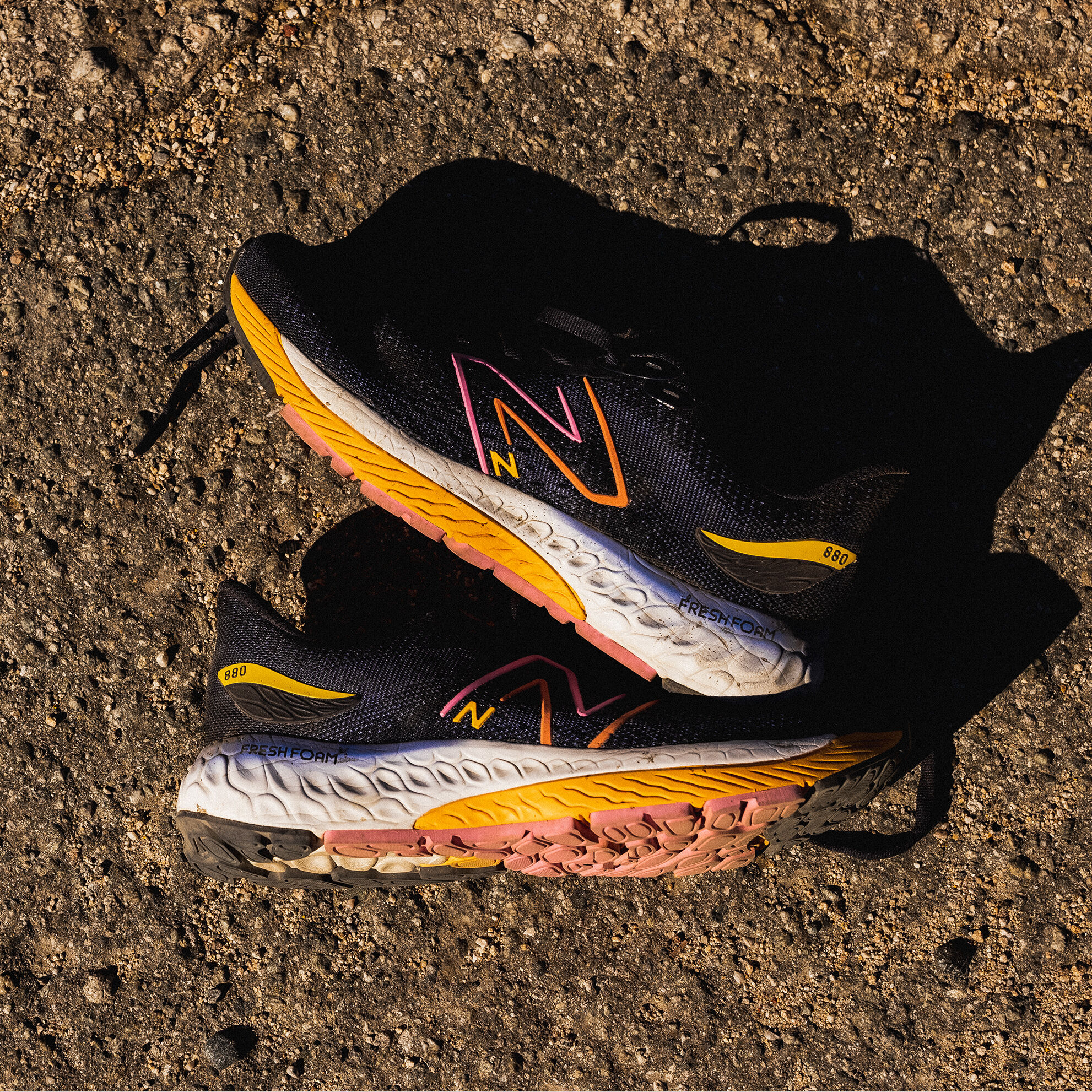 A pair of navy Fresh Foam 880 shoes on a dirt path