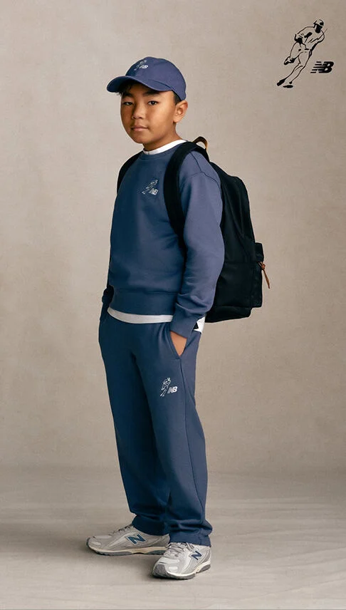 Kid standing against a grey studio background.