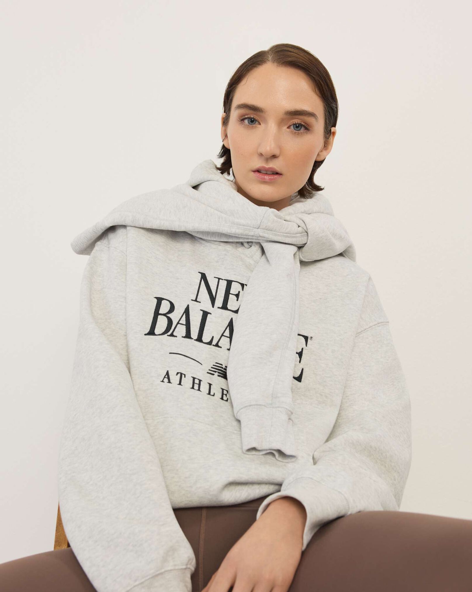 A woman standing in front a white wall.