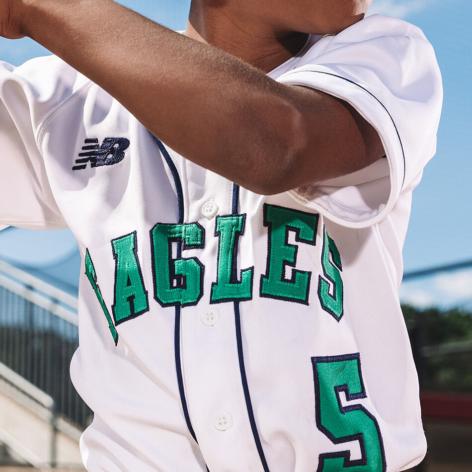 Crop of a young baseball player’s NB jersey as he takes an at bat