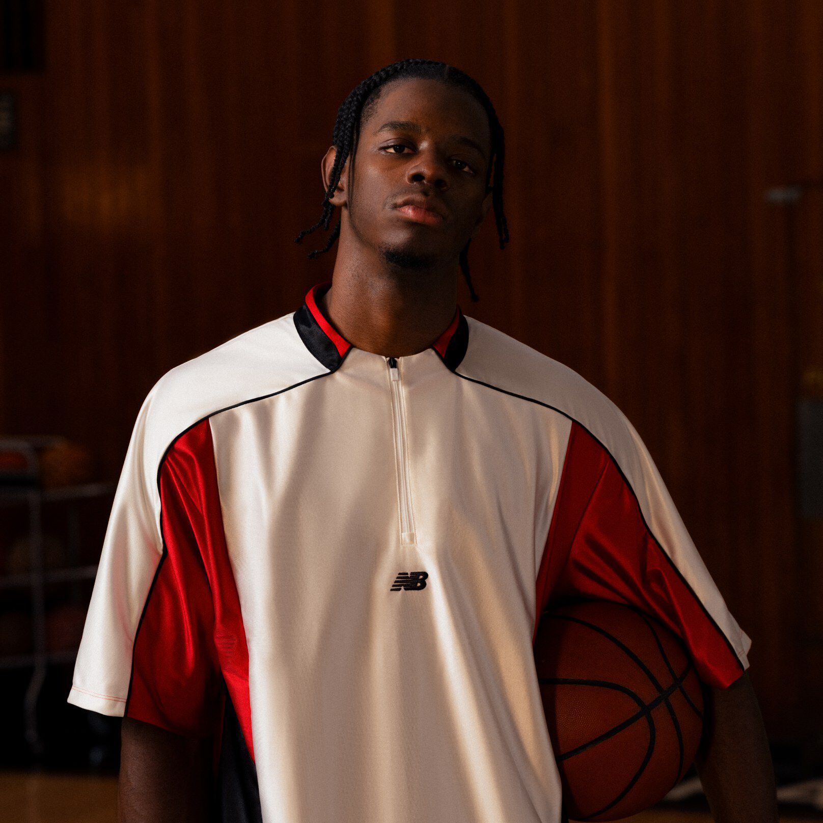 Player standing with a basketball by his hip