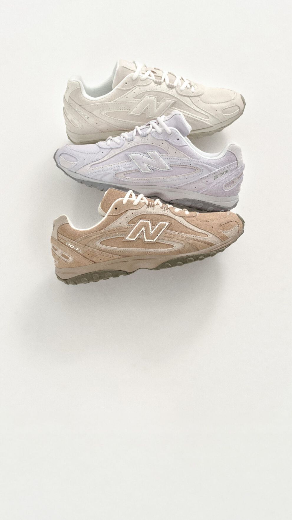 Three pairs of New Balance sneakers on a white background.