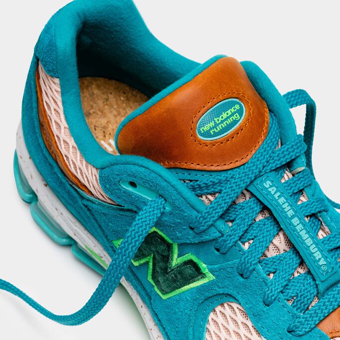 Top detail shot of a turquoise NB x Salehe Bembury 2002R with orange leather and lime green accents and a cork insole