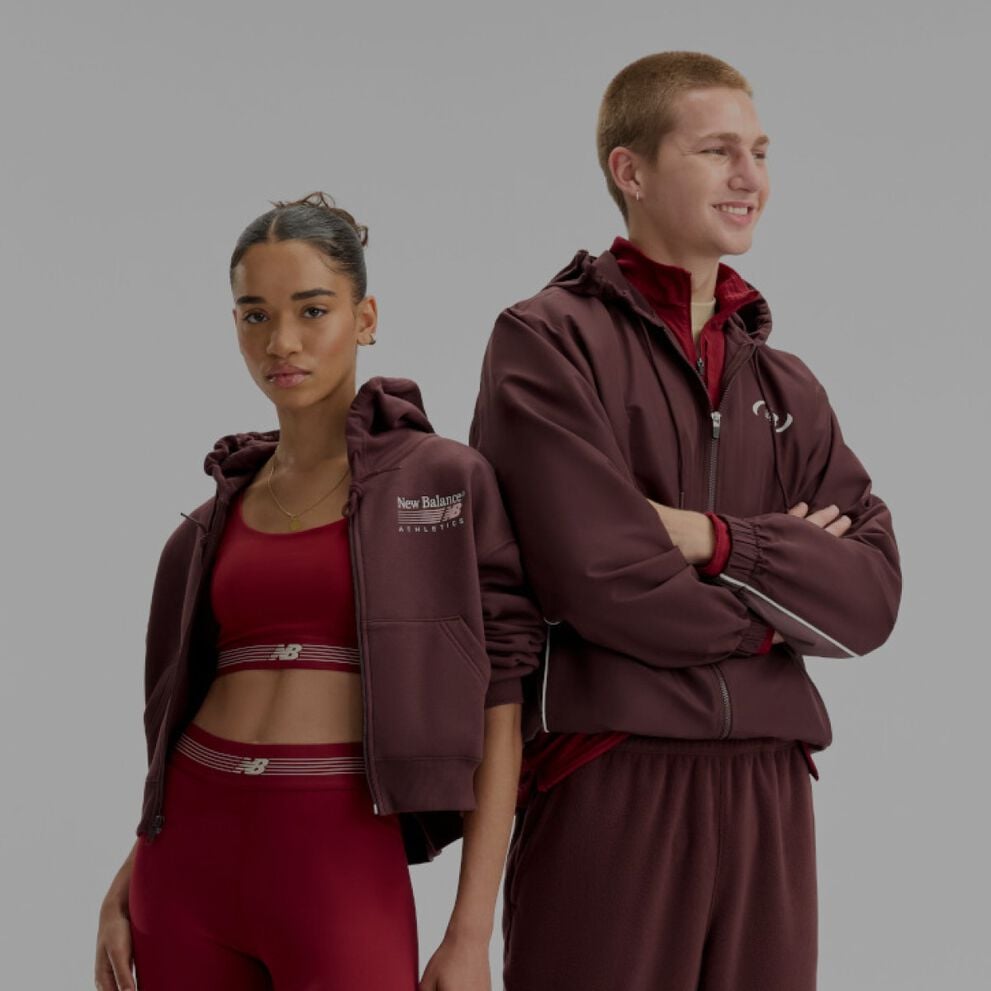  A man and woman wearing burgundy and red New Balance gear on a white background..