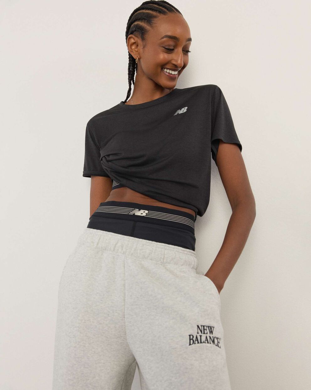 A woman standing in front a white wall.