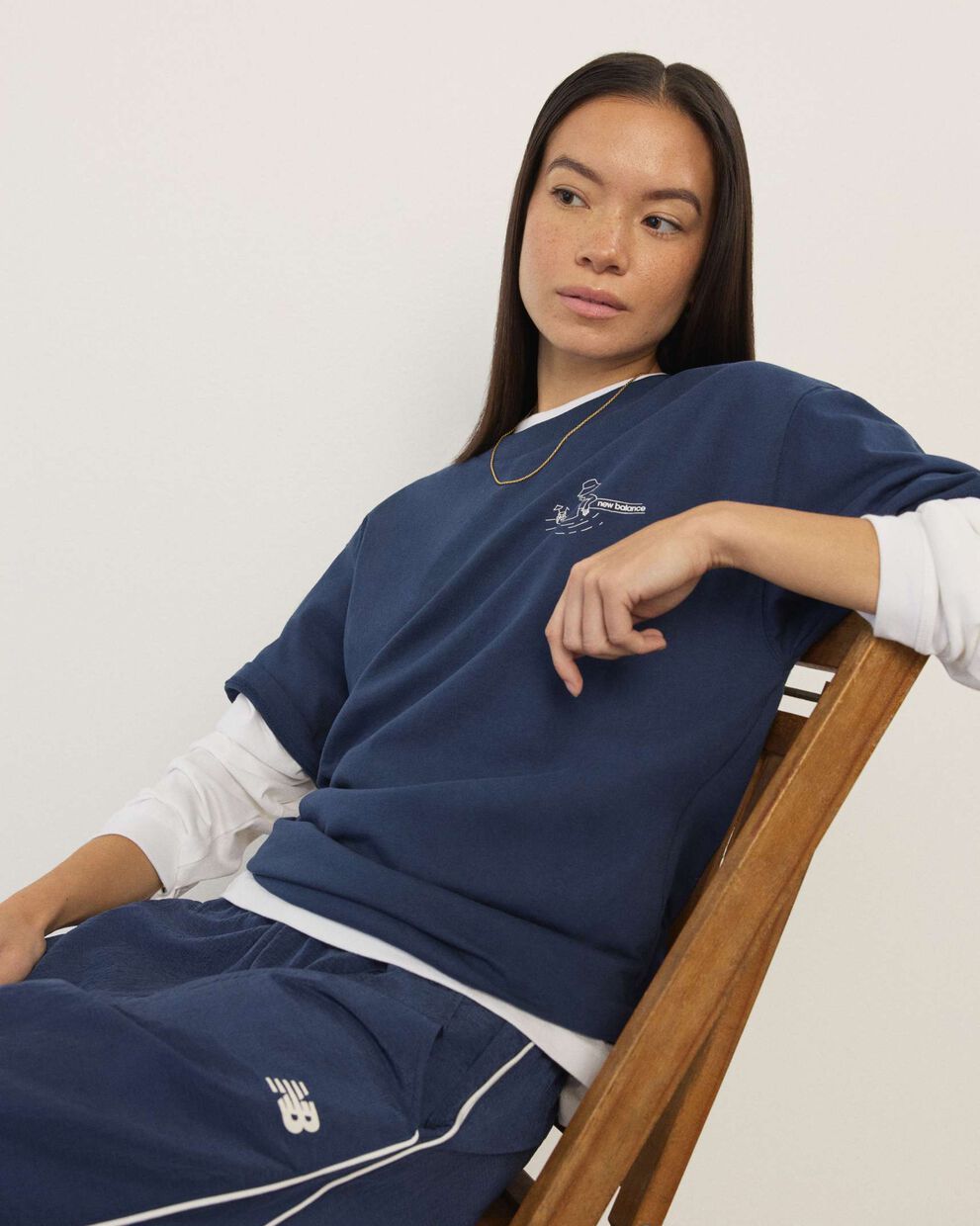 A woman standing in front a white wall.