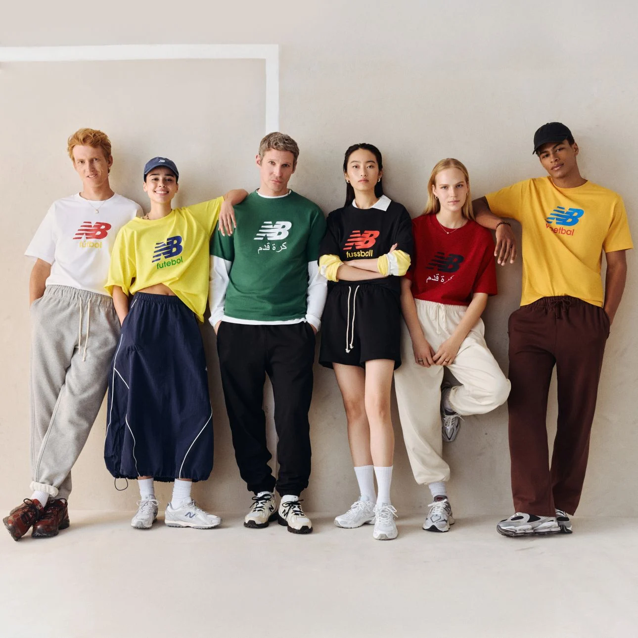 A group of people wearing different color soccer graphic t-shirts.