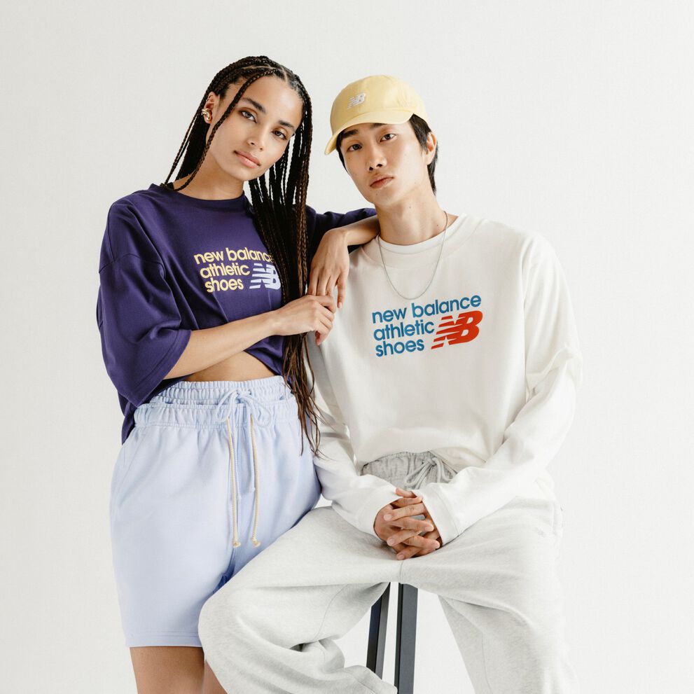 A man and woman in front of a grey studio backdrop.