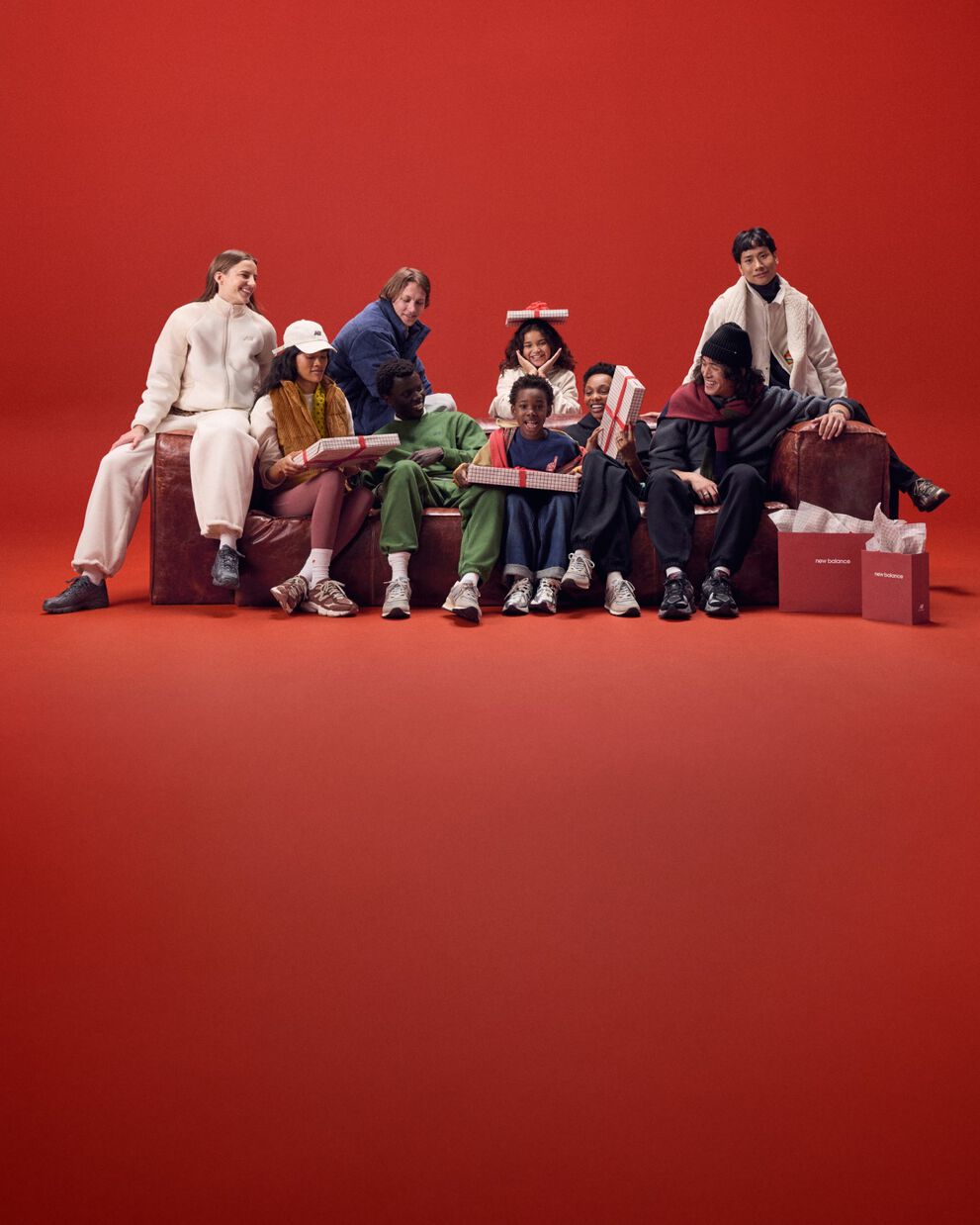 Young family sitting on a red couch with gifts.