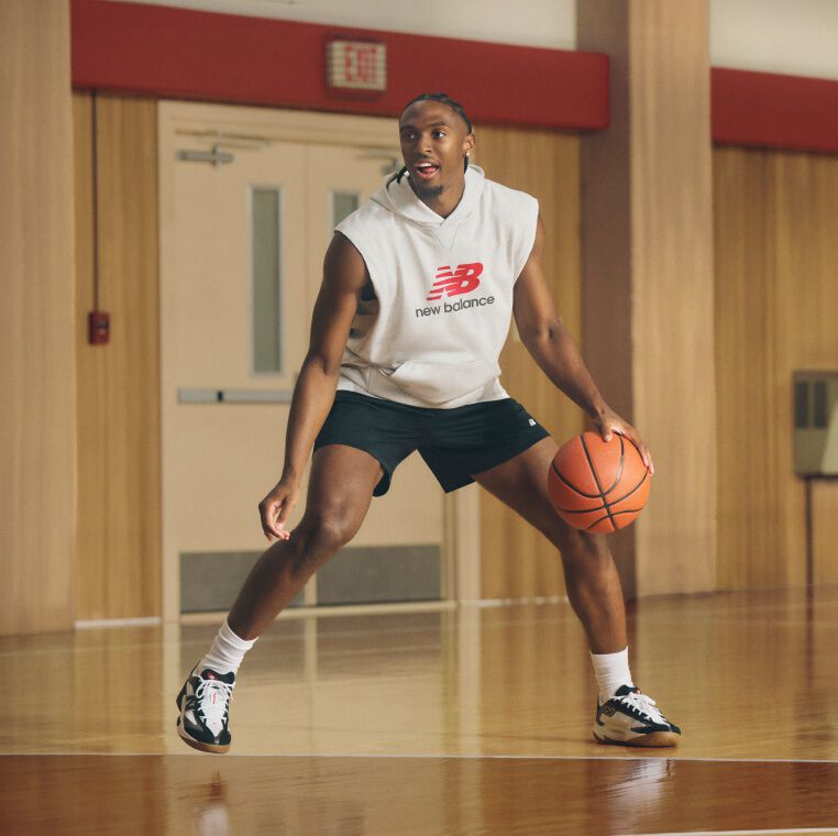 Jugador de baloncesto con pantalones cortos negros que regatea un baloncesto